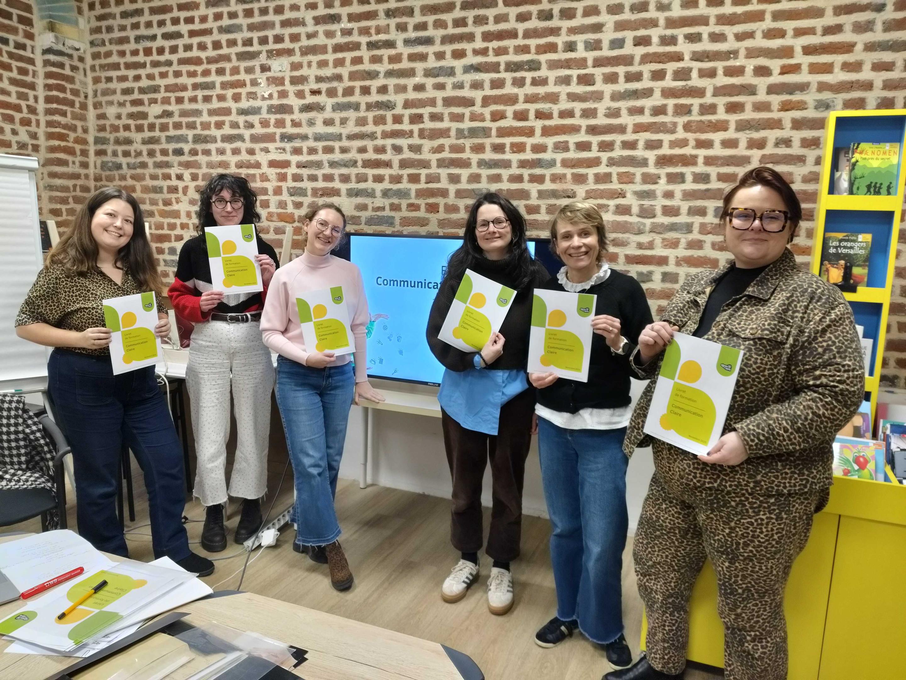 Un groupe d'apprenantes posent avec le livret de formation.