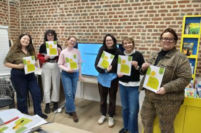 Un groupe d'apprenantes posent avec le livret de formation.